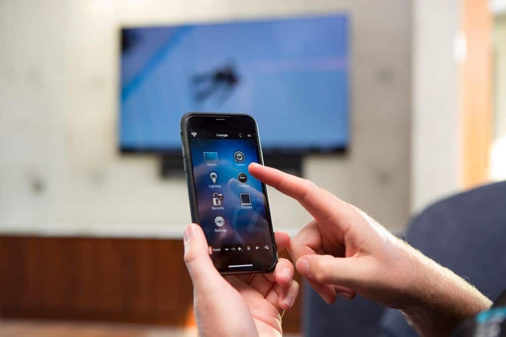 Woman using smart home control app on her phone to control aspects of the house