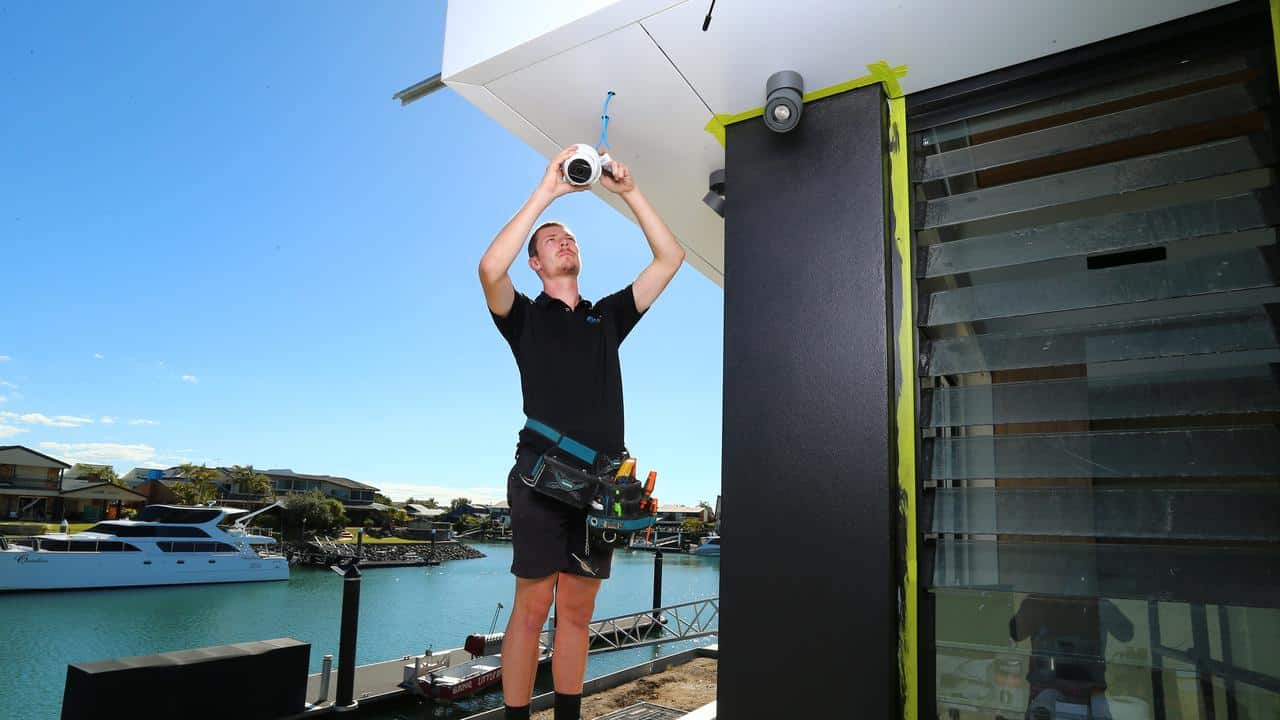 Electronic Living installation technician installing a CCTV surveillance camera into a home in Brisbane.